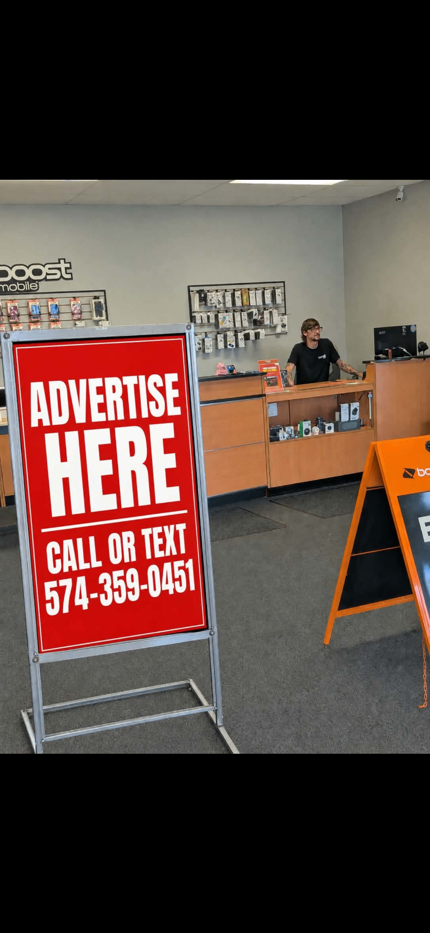 Advertise Here sidewalk sign displayed inside a local Boost Mobile store