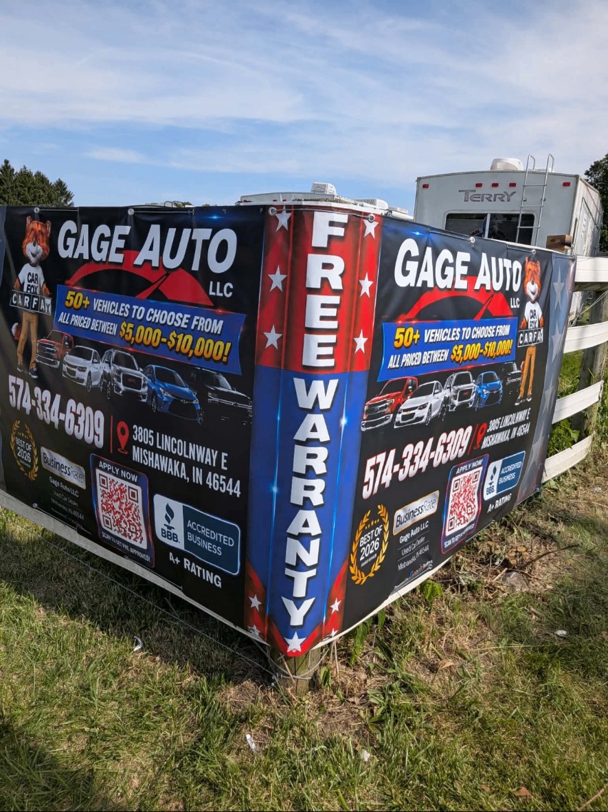 Large double-sided Gage Auto LLC banner installed on a roadside fence